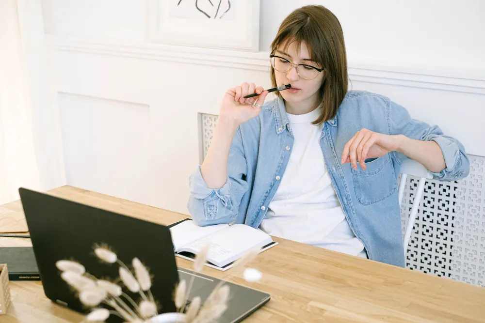 AC Repairs vs. Maintenance: What You Need to Know - Woman sitting at desk.