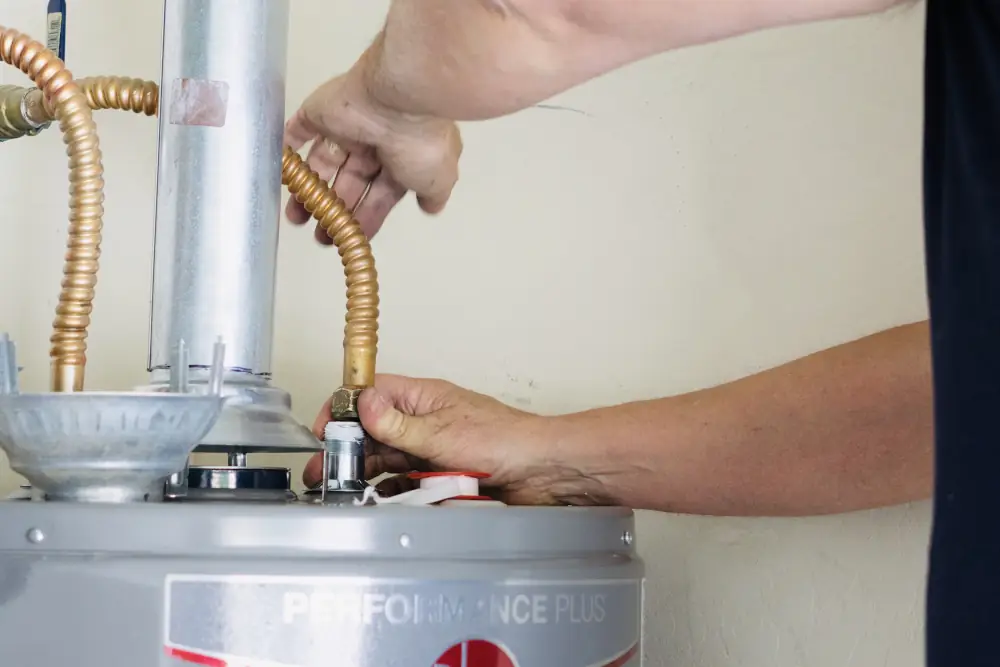 Renting or owning your water heater - HVAC technician working on a water heater.